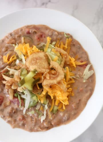 Closeup photo of a bowl of bacon cheeseburger soup with toppings.