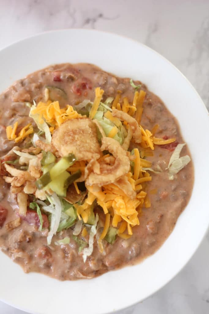 Closeup photo of a bowl of bacon cheeseburger soup with toppings.