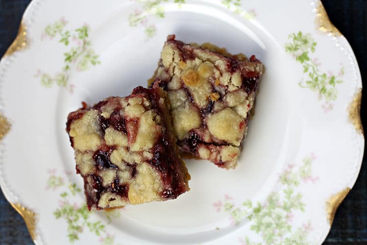 Two raspberry bars on a plate.