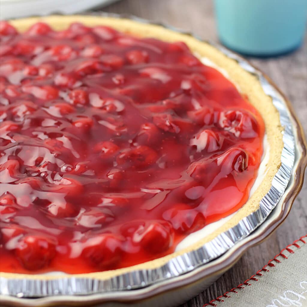 Side closeup view of cherry pie in a tin pie plate.
