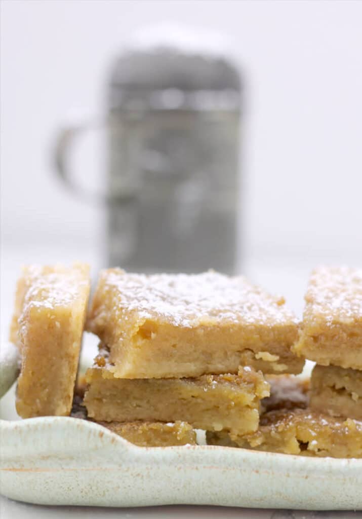Chess squares stacked on a plate with powdered sugar on top.