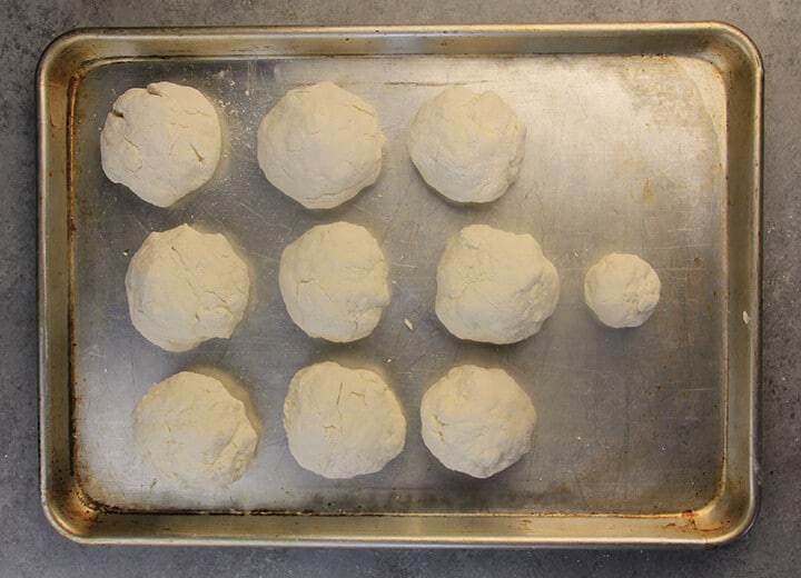 Rolled out biscuits on a pan to bake.