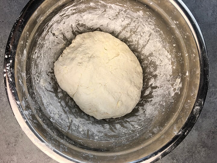 Smooth biscuit dough in a stainless bowl.