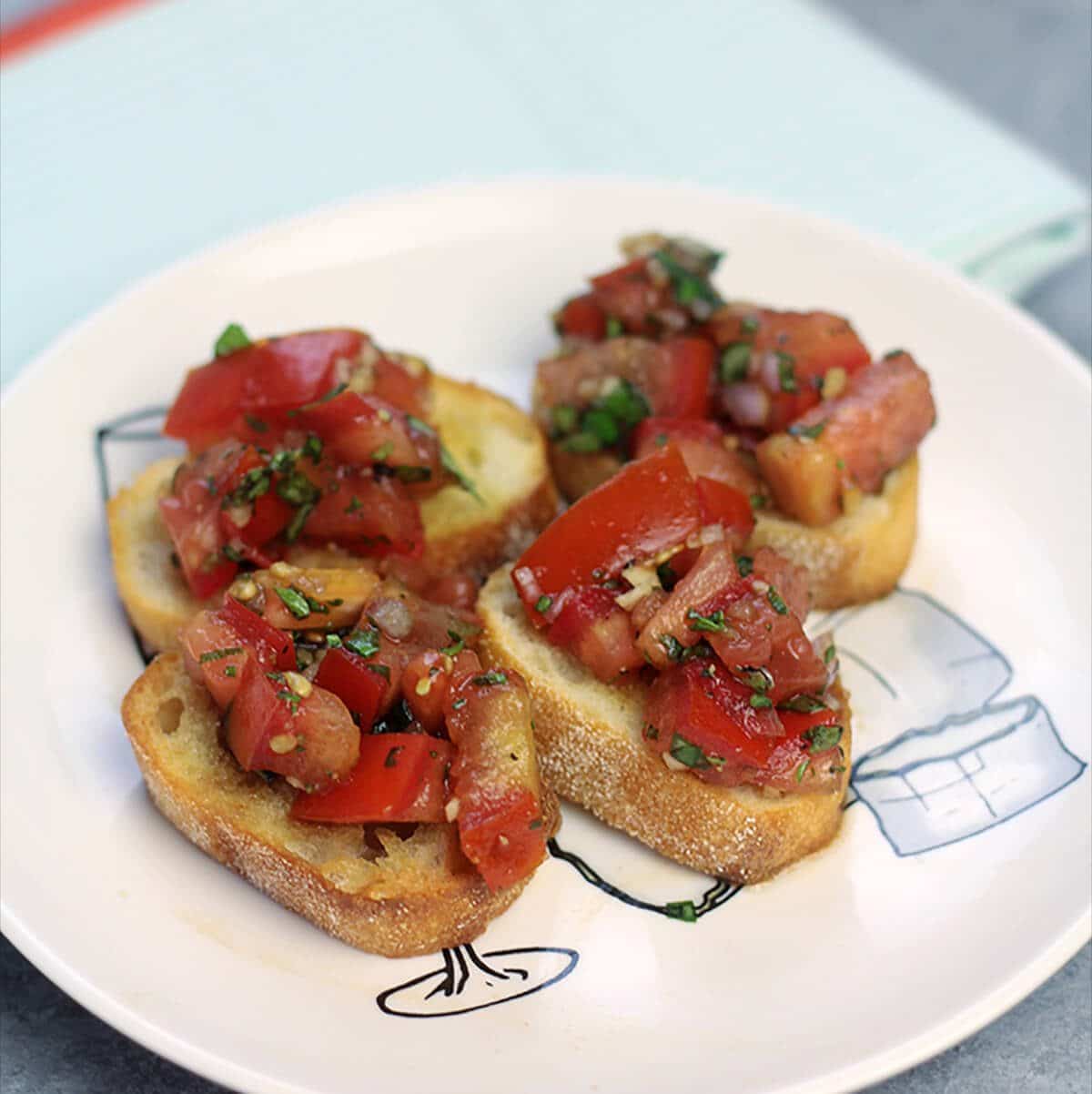Bruschetta on toasted bread on a plate.