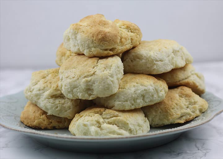 Plate of stacked homemade buttermilk biscuits.