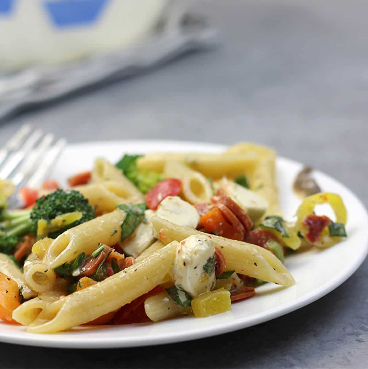 Pizza Pasta Salad with pepperoni, peppers, tomatoes, and mozzarella balls is super easy--and perfect for tailgates. Minimal chopping is required and you can mix and match ingredients.