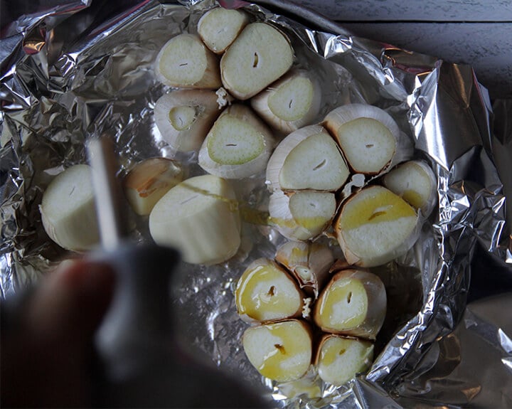 Heads of garlic in foil for roasting.