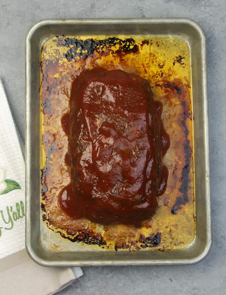 Southern meatloaf recipe with a whole baked meatloaf on a baking sheet. 
