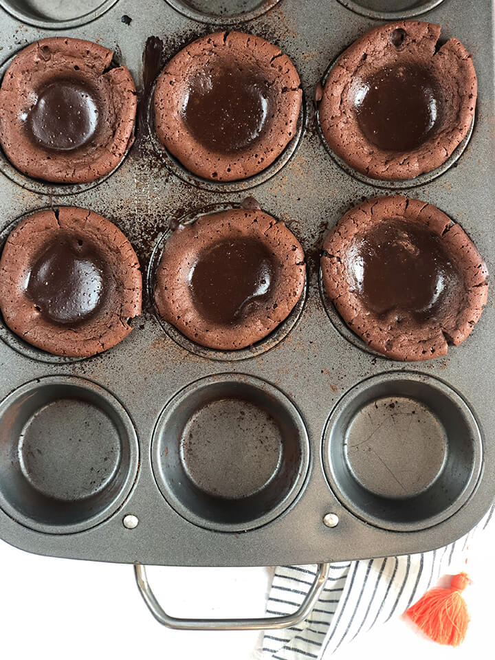 Baked chocolate lava cakes in a muffin pan.