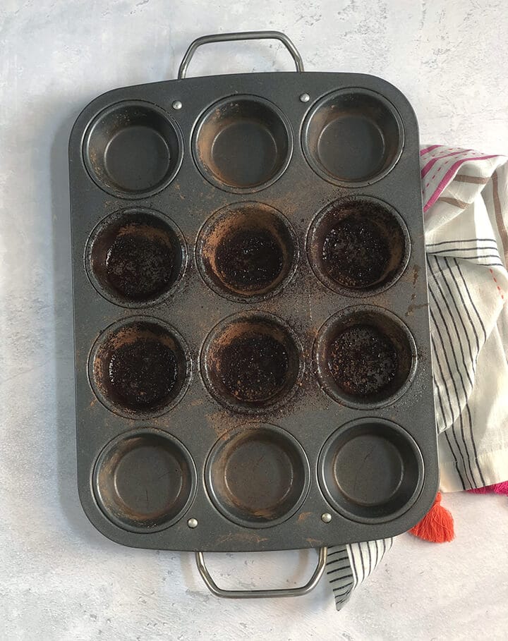 Muffin pan dusted with cocoa for baking chocolate molten lava cakes.