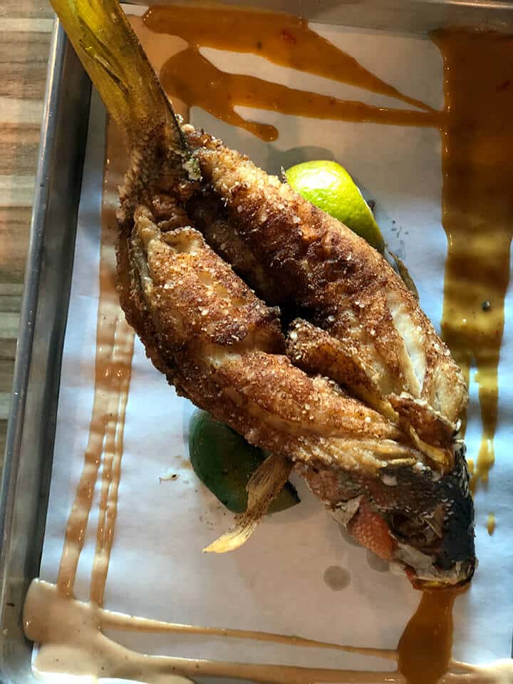 Whole fish lightly battered and fried on a tray.