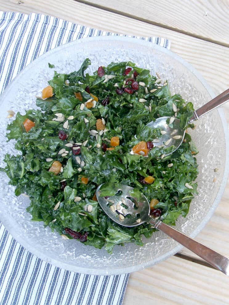 Overhead of a bowl of a salad with salad tongs.