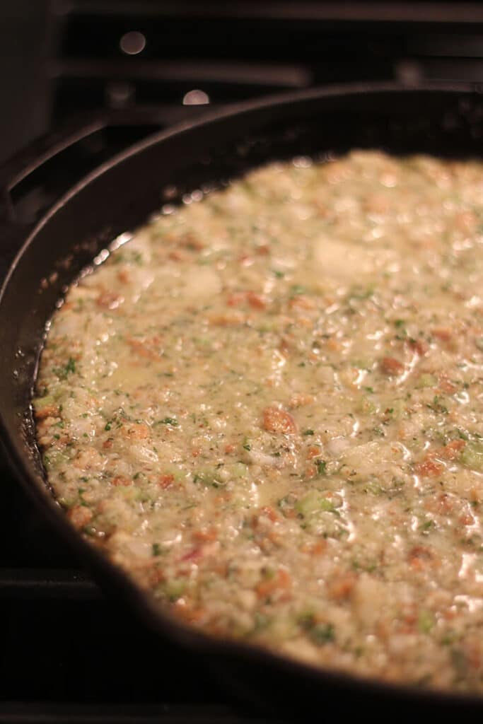 Cast iron skillet with cornbread dressing ready to bake.