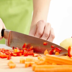 A person cutting a piece of food, with Kitchen and Tool
