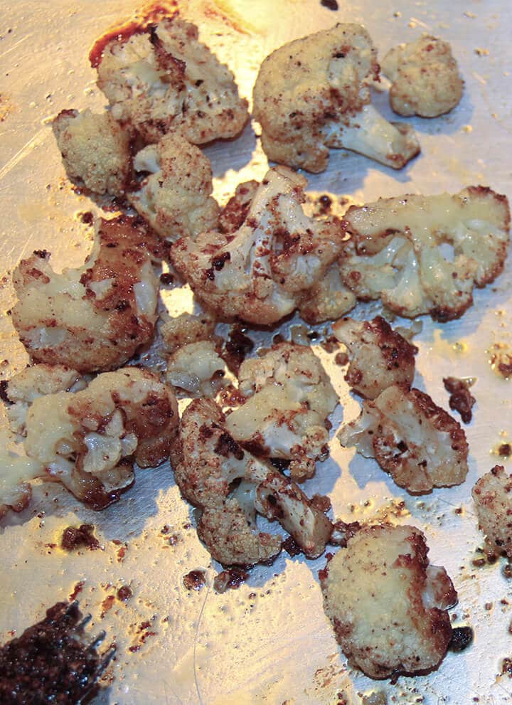 Spicy roasted cauliflower on a baking sheet.