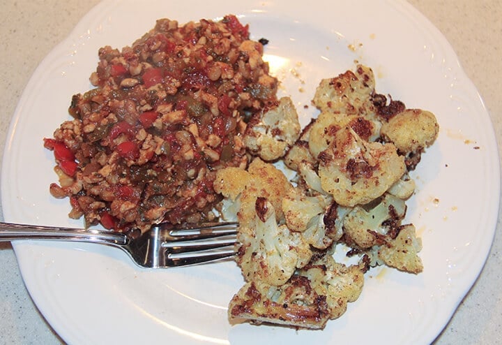 Spicy roasted cauliflower on a white plate with a fork.