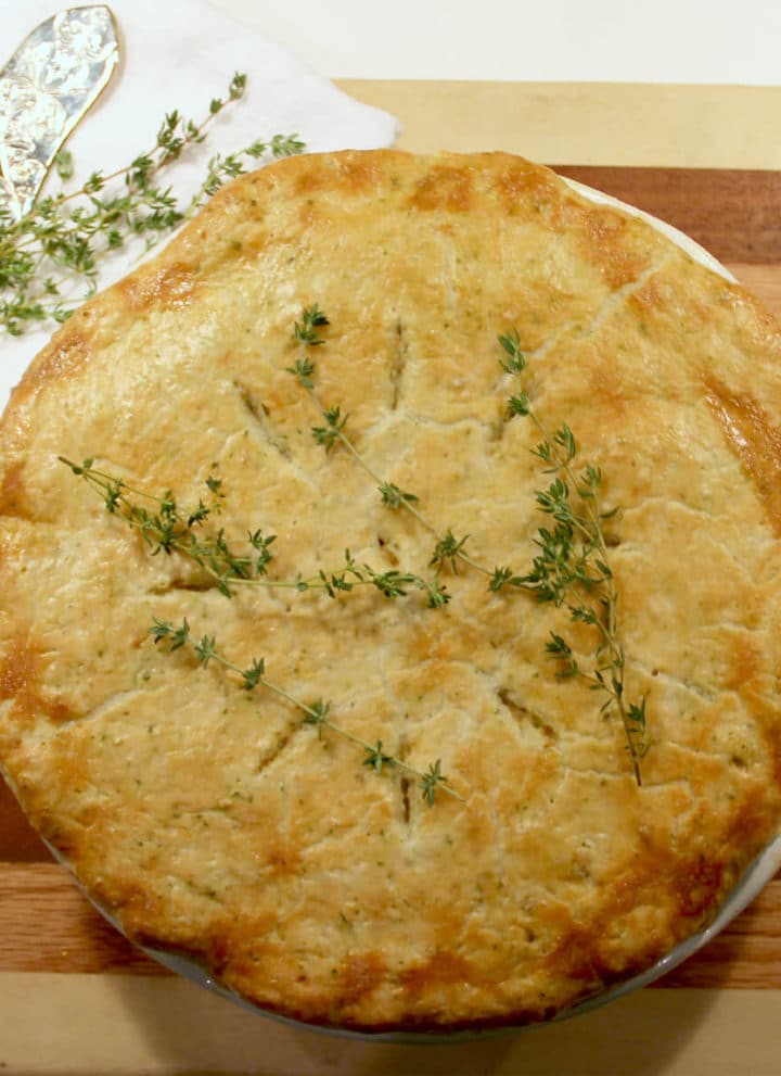Overhead photo of a whole double crust chicken pot pie on a wooden board.