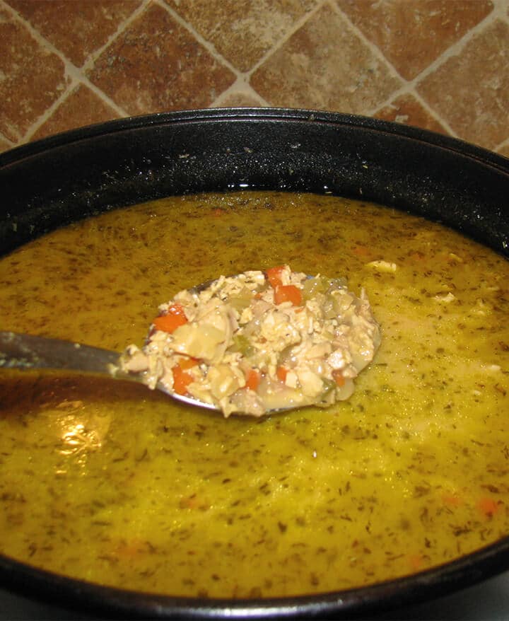 A spoon of Southwest Chicken Soup over a large pot of soup.