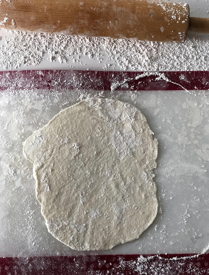 Dough rolled out on floured surface ready to cut into dumplings.