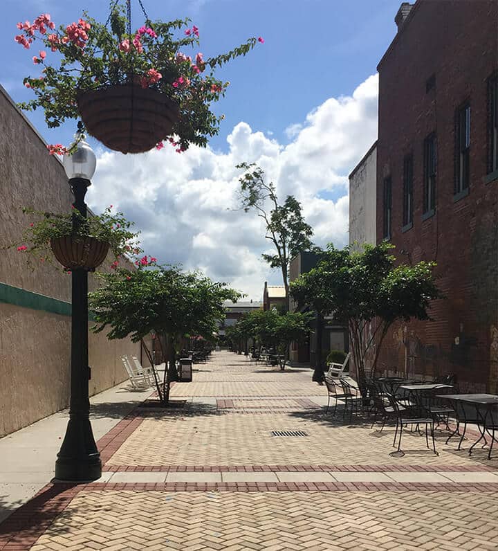 A brick-lined alley with tables and chairs in downtown Aiken, SC.