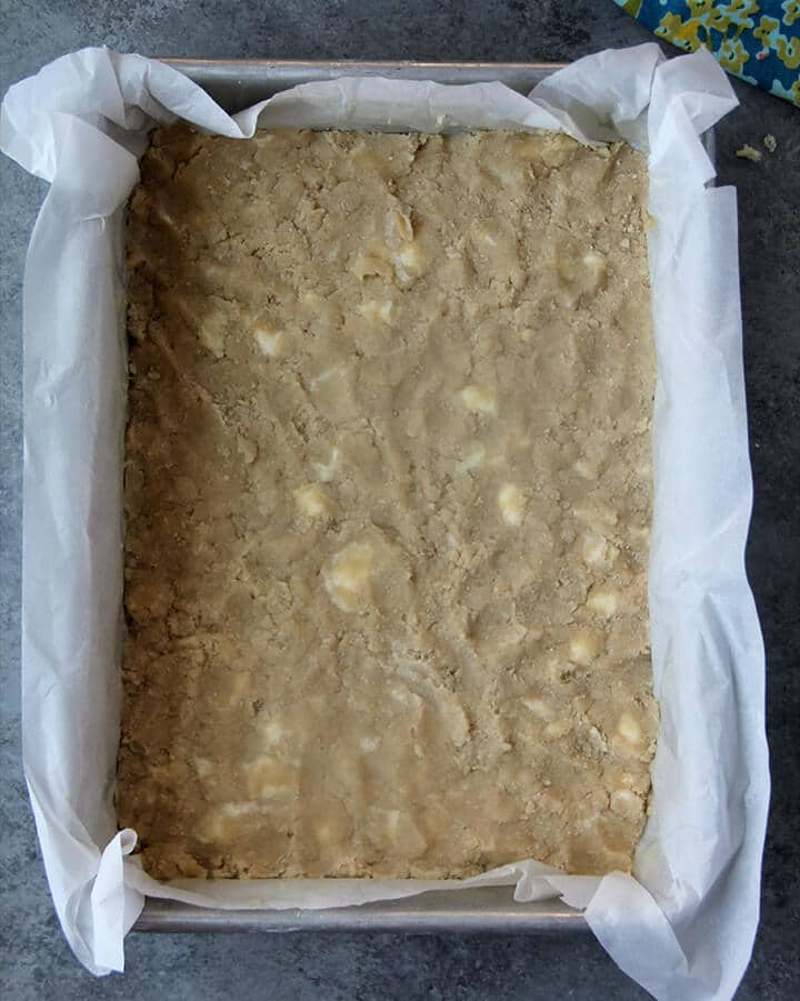 Shortbread crust for easy lemon bars pressed into a parchment lined pan.