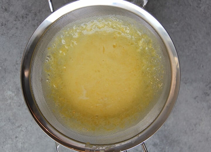 Lemon filling in a stainless steel strainer.