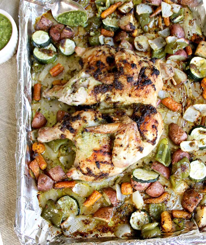 Pesto Chicken and vegetables on a foil lined sheet pan.