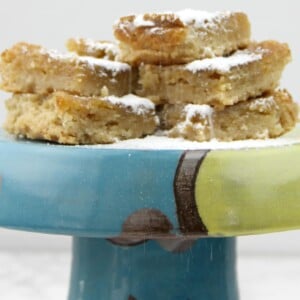 Chess squares stacked on a platter and topped with powdered sugar.