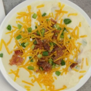 A bowl of potato soup with all the toppings.