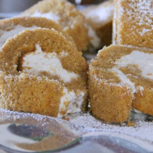 Closeup of pumpkin roll with cream cheese filling on a platter.