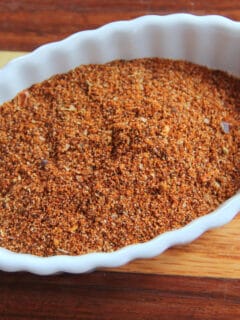 A white bowl of homemade taco seasoning on a cutting board.