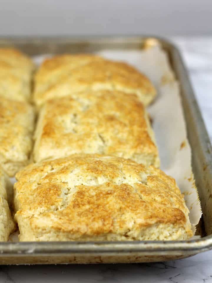 Baked strawberry shortcake biscuits on a baking pan.