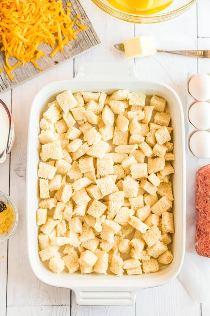 Bread cubes in a white dish for breakfast casserole.