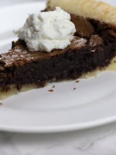 A slice of fudge pie on a white plate.