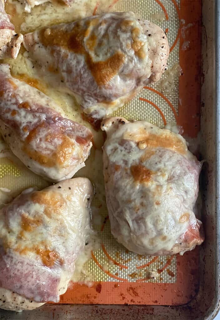 Prosciutto wrapped chicken on a baking sheet.