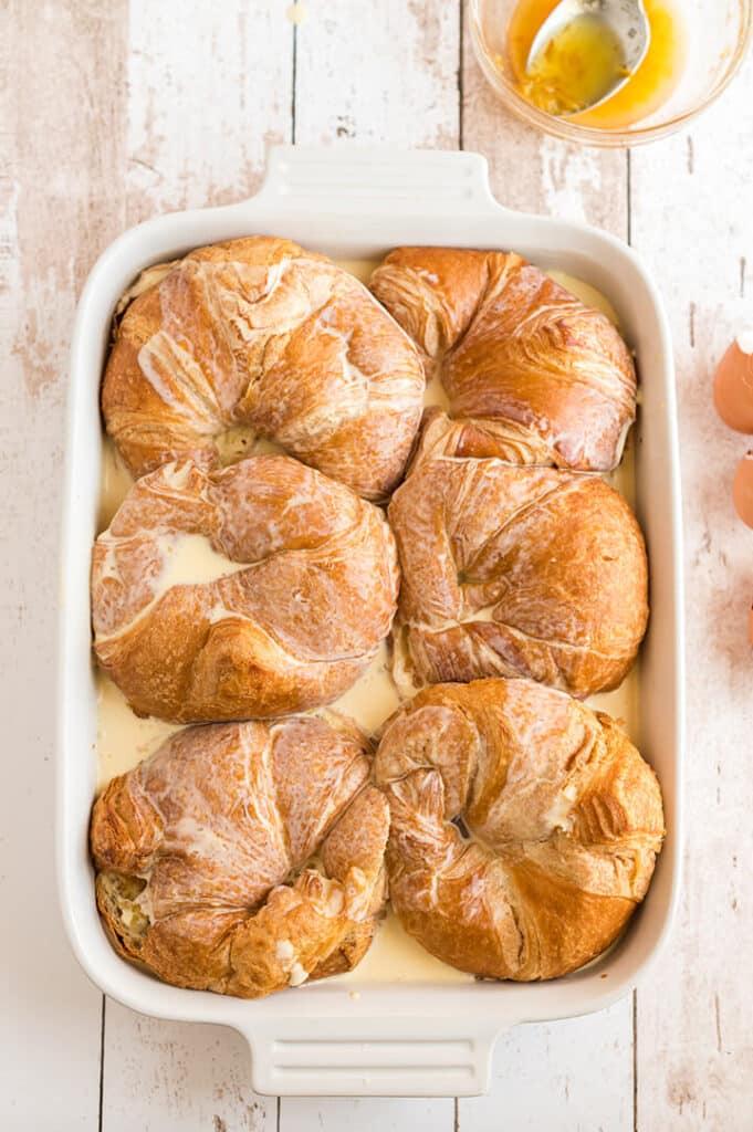 Croissants in a white baking dish.