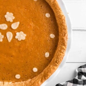 Overhead view of half a sweet potato pie in a white plate.