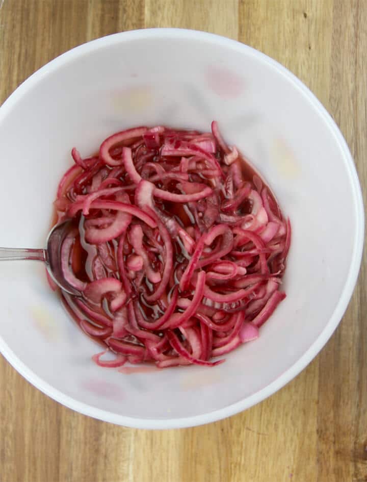A bowl of onions with vinegar poured over to make pickled onions.