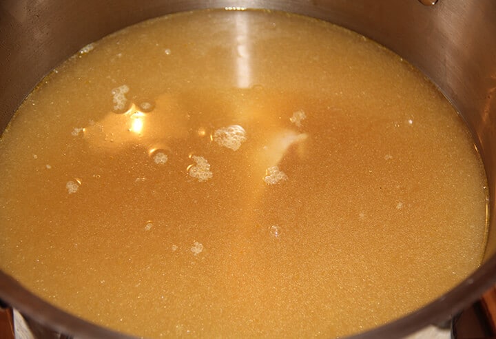 A stainless pot of chicken stock.
