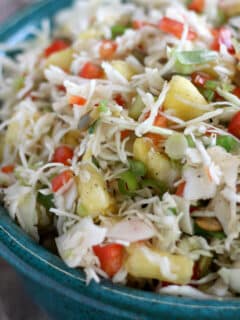 Closeup photo of pineapple slaw in a blue pottery bowl.