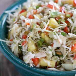 Closeup photo of pineapple slaw in a blue pottery bowl.