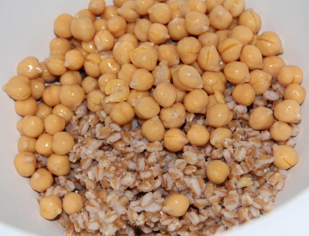 Cooked farro and chickpeas in a white bowl.