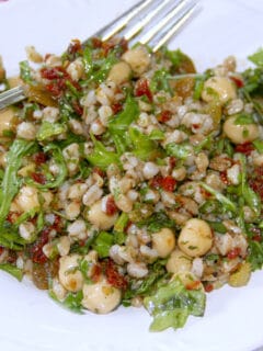 A white bowl filled with farro salad with a fork on the side.