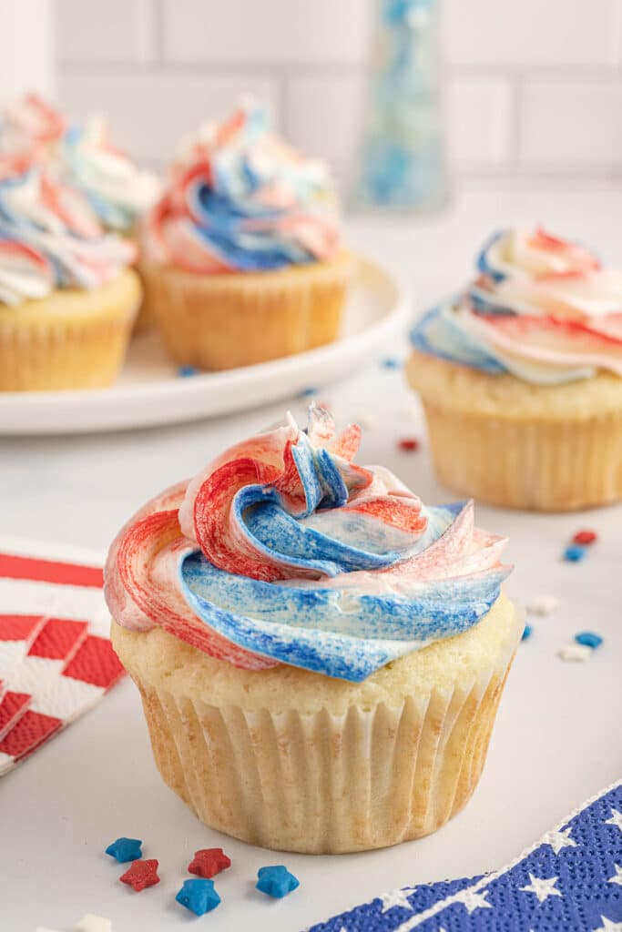 Closeup of a cupcake with red, white, and blue swirled frosting.