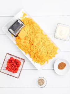Grated cheese, pimentos, cayenne pepper, and mayonnaise ready to make pimento cheese.