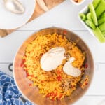 Grated cheese and pimentos in a stainless steel mixing bowl.