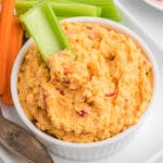 Pimento cheese in a small white bowl with celery.
