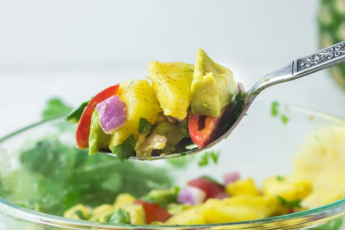 spoonful of salsa over a white bowl.