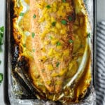 close up of baked salmon topped with diced pineapple.