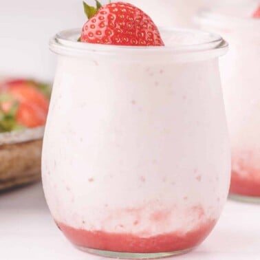 jar filled with strawberry mousse with a strawberry on top